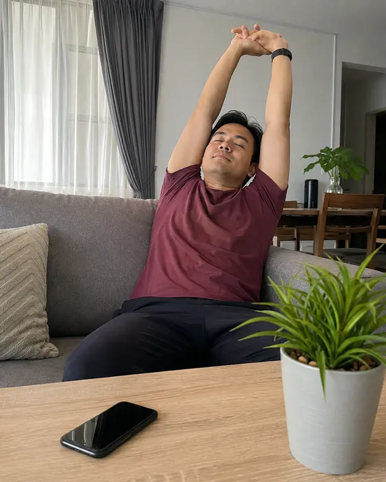 Seorang lelaki dewasa berehat dengan telefon diletakkan di atas meja